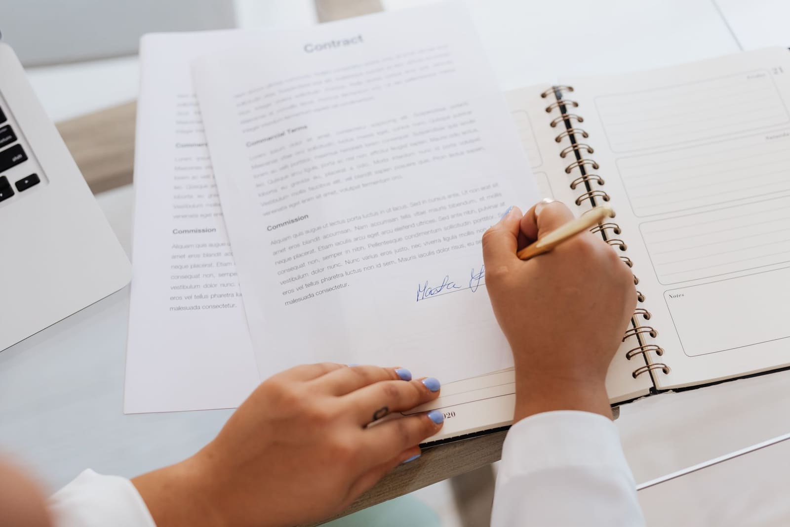 A contract being signed at a desk